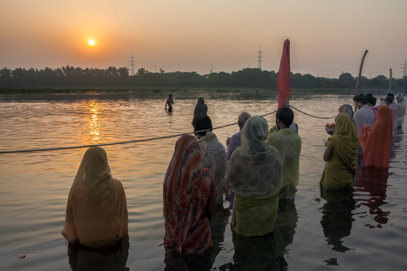 The connection between Water and Religion - Devotees praying and meditating while standing in the waters of river Yamuna during Chath Puja celebrations in North-East district, National Capital Territory of Delhi